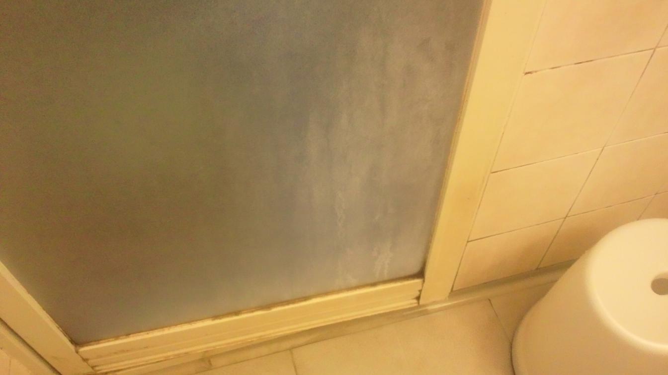 石鹸かすで汚れた浴室のドア