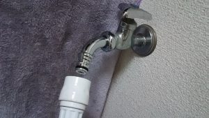 洗濯機用の蛇口からホースを引っ張る